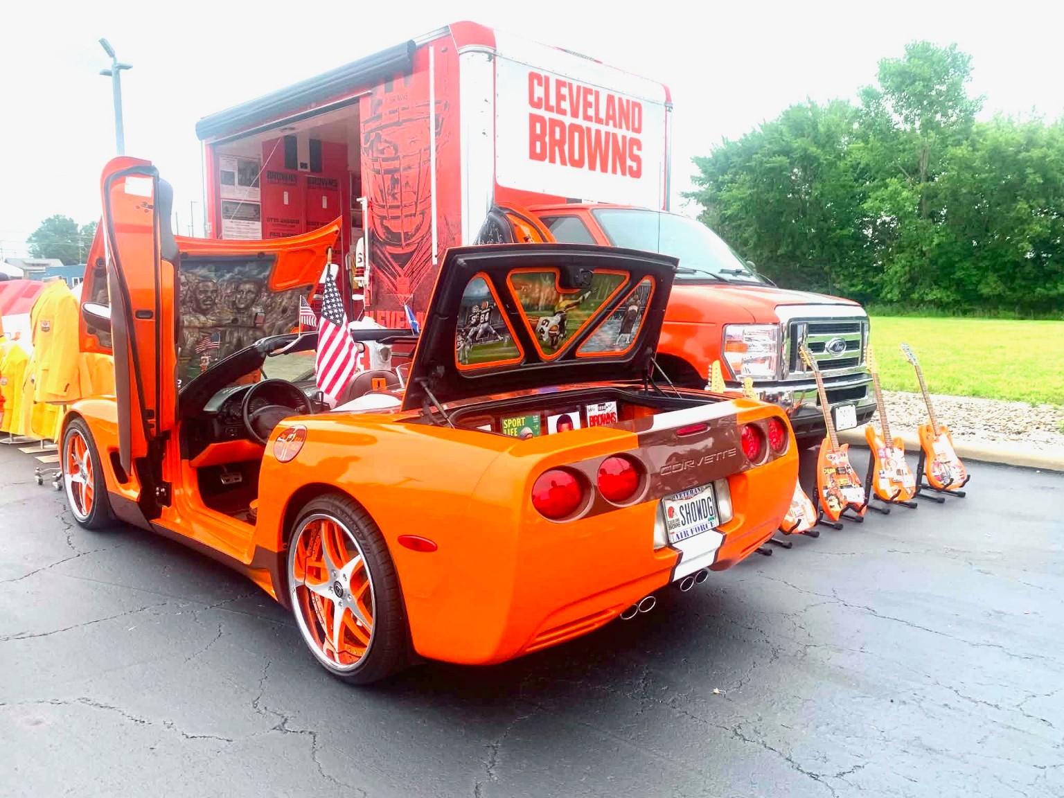 Doors up, trunk open — JB’s full display, tailgate tribute guitars behind